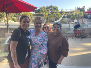 4 women smiling on a patio outdoors