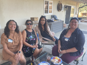 4 women sitting at an outdoor patio couches